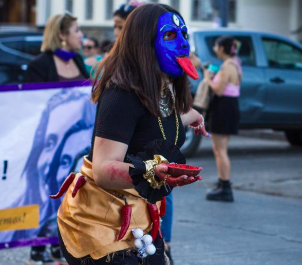 Mujer con máscara azul en la marcha de chillán