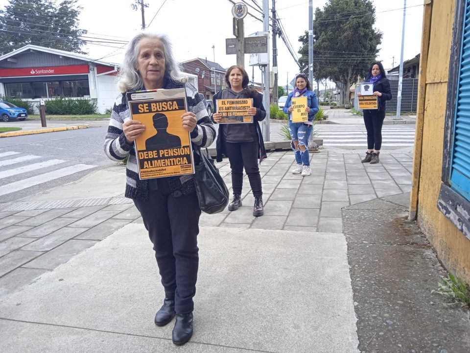 Cuatro mujeres una atrás de la otra sostienen carteles de la campaña "Cuidado el machismo mata"